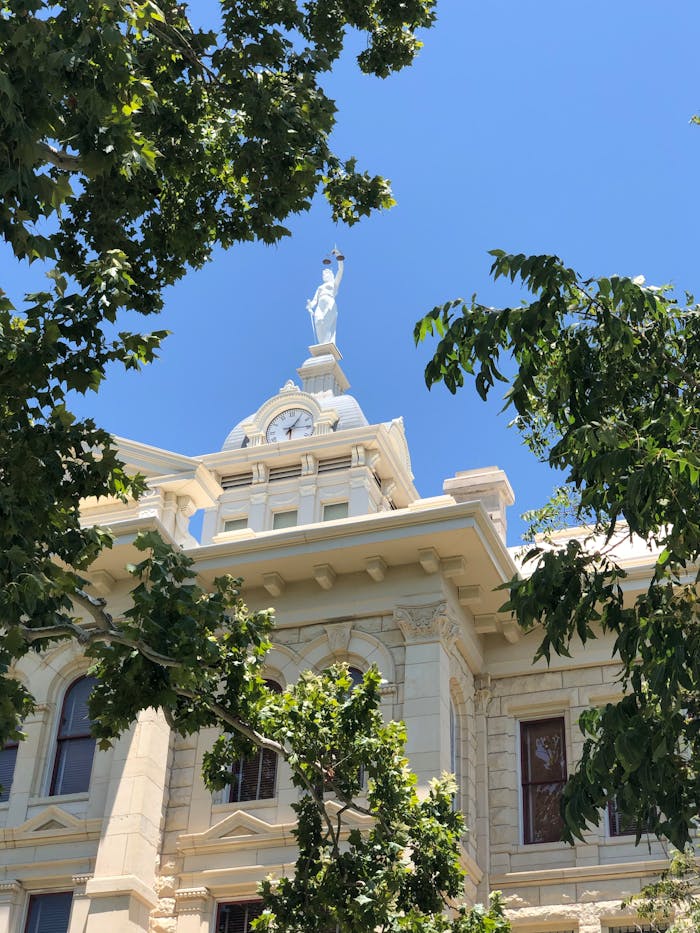 pexels-photo-15447948 Low angle view of Milam County Courthouse against clear blue sky in Texas.